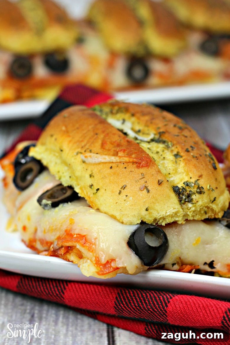 Sheet Pan Pepperoni Sliders Recipe — Quick Party Appetizer 8 Sheet Pan Pepperoni Pizza Sliders On Plate