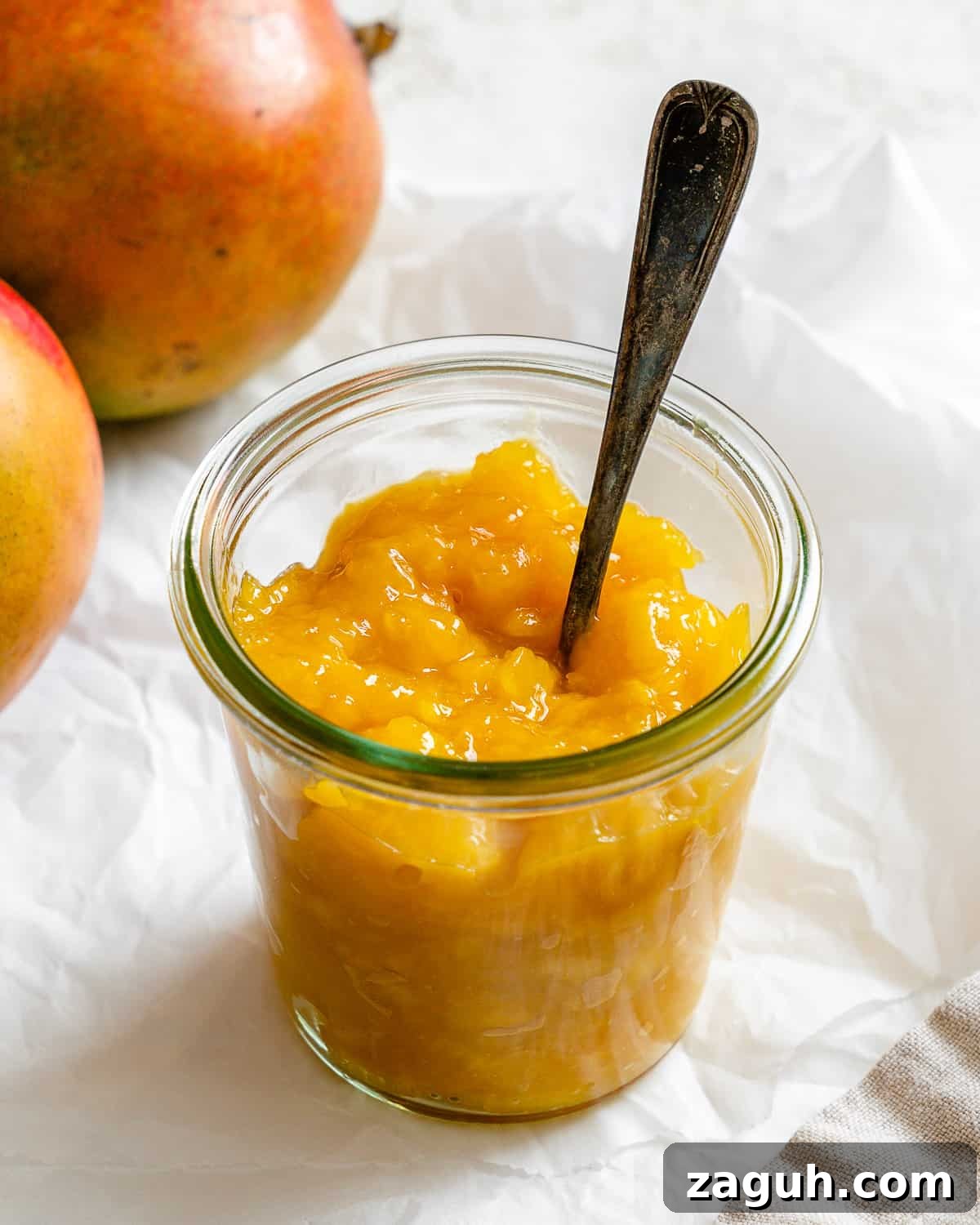 3-Ingredient Mango Compote (Simple Coulis Recipe) 2 completed mango compote in a jar against a light background