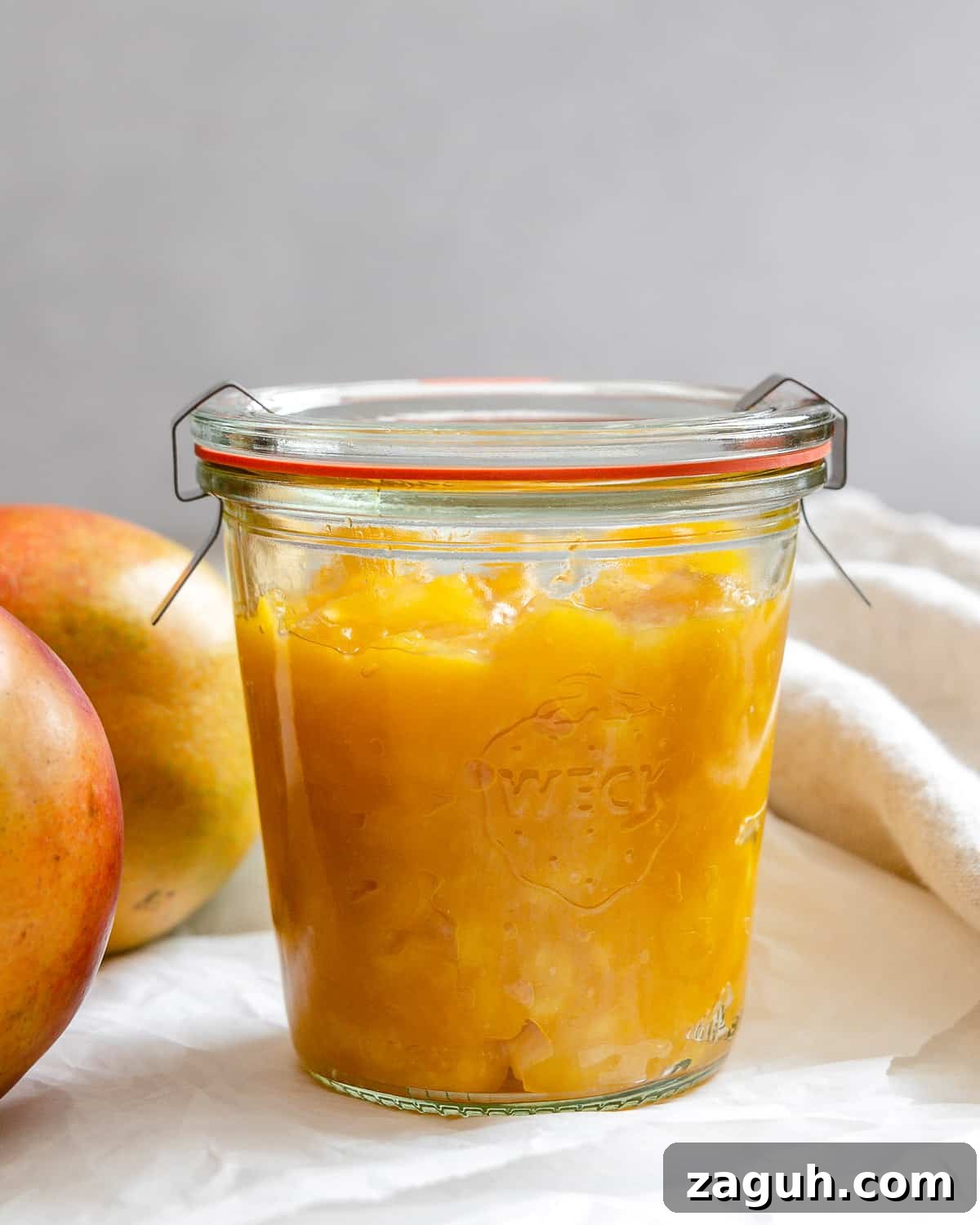3-Ingredient Mango Compote (Simple Coulis Recipe) 11 completed mango compote in a jar against a light background