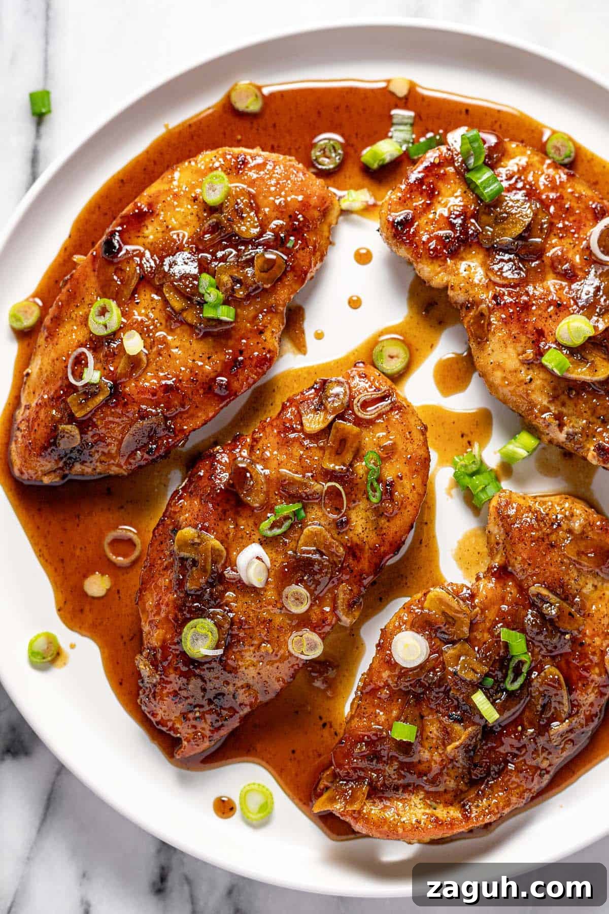20-Minute Garlic Chicken with Honey Glaze 2 Large round plate with honey garlic chicken garnished with sliced green onion.
