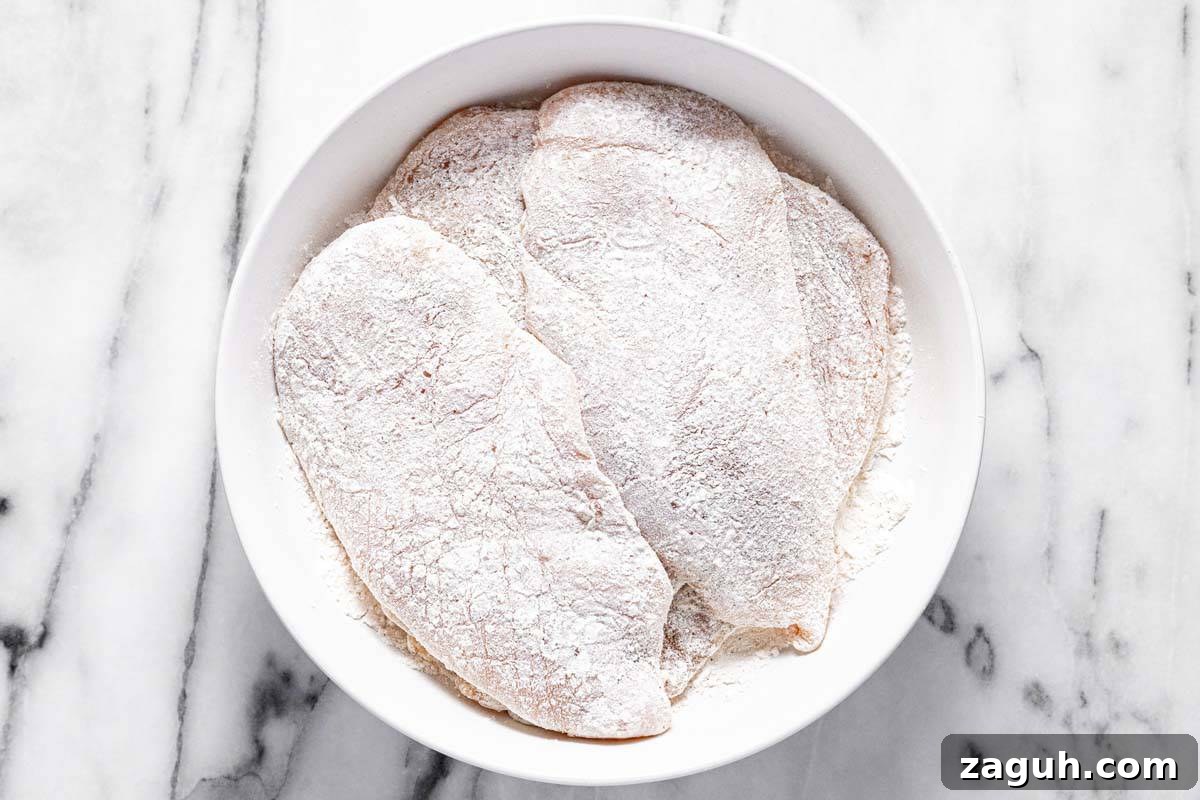 20-Minute Garlic Chicken with Honey Glaze 4 Large bowl filled with flour dredged pieces of chicken breast.
