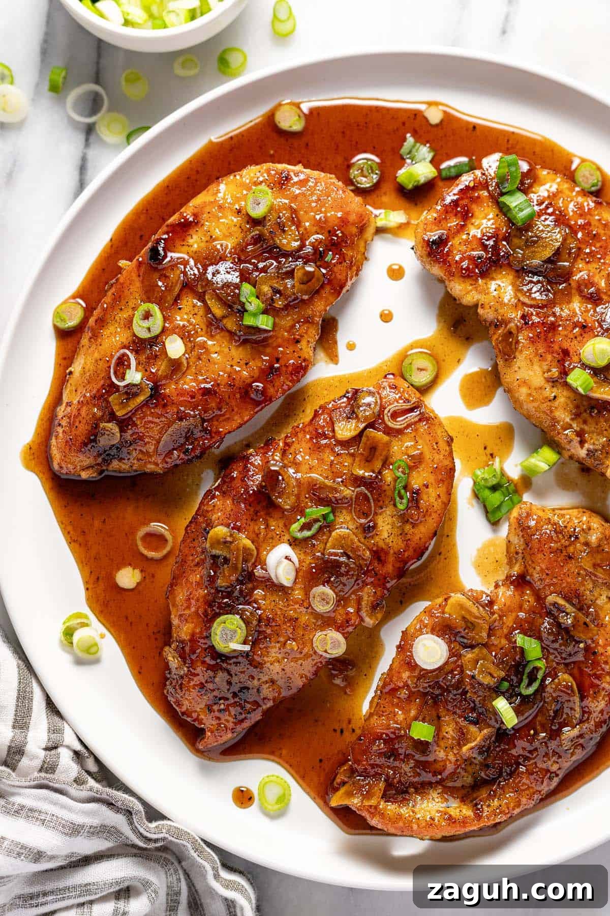 20-Minute Garlic Chicken with Honey Glaze 8 Large round plate with honey garlic chicken garnished with sliced green onion.