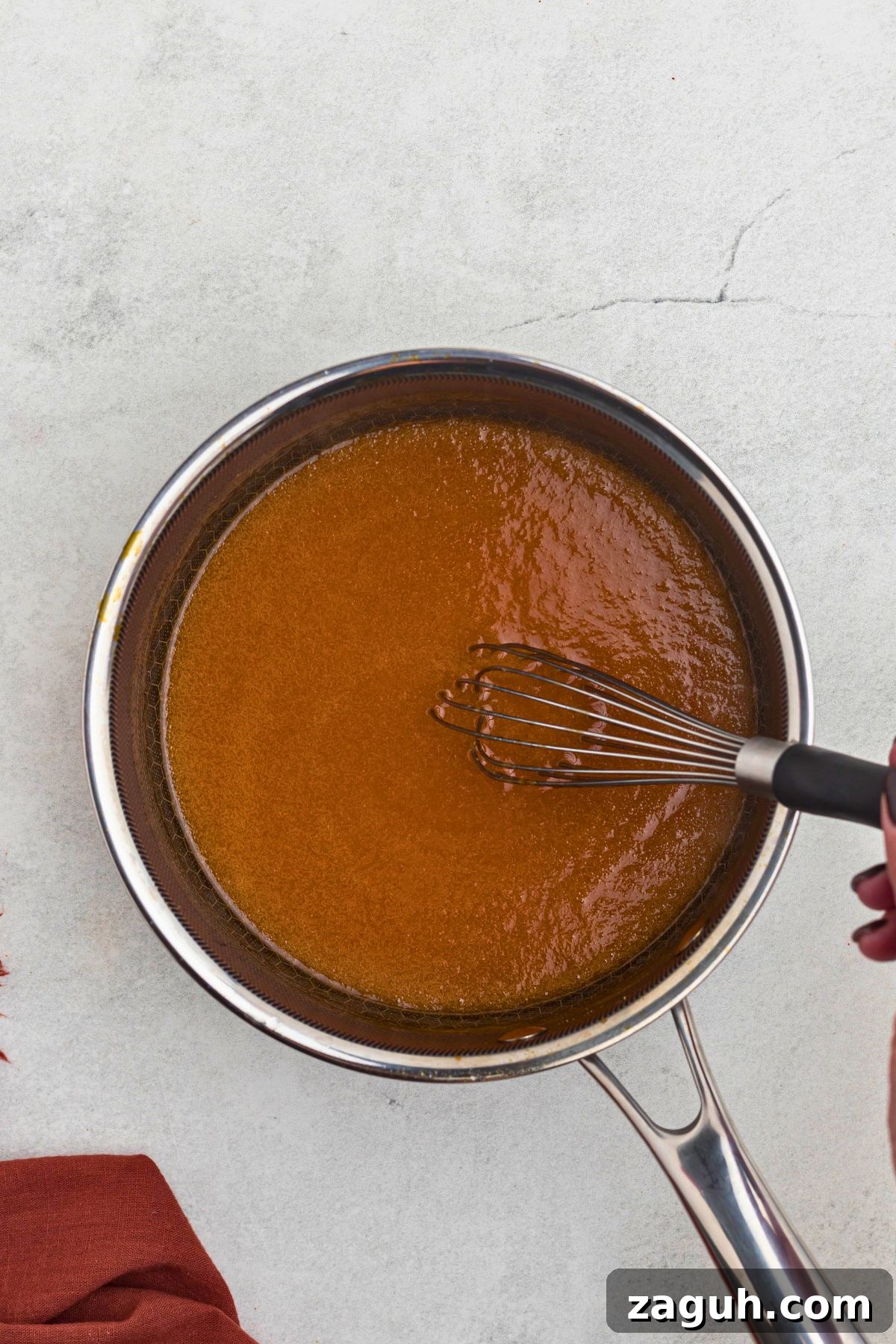 Classic Buffalo Sauce Recipe: Spicy Wing & Dip Sauce in Minutes 5 Creamy, buttery, orange sauce being whisked together in a saucepan.