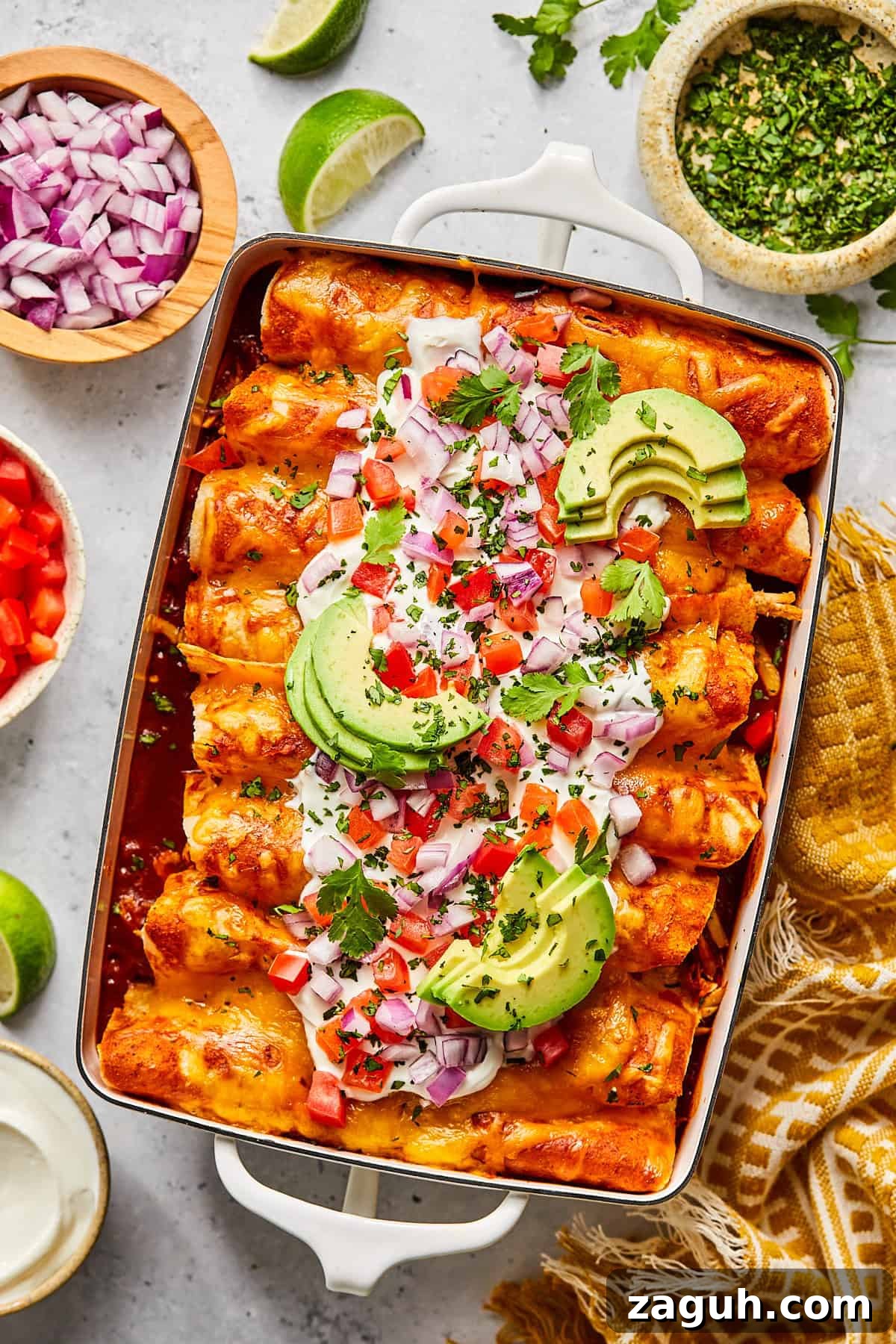Chicken and black bean enchiladas with toppings in a casserole dish