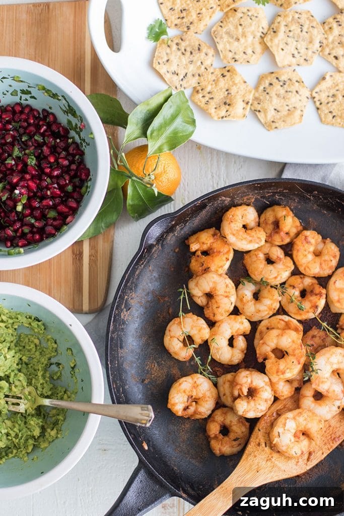 Mini Shrimp Tostadas with Pomegranate Guacamole / The perfect healthy party appetizer! Blackened shrimp, guacamole, and a tangy pomegranate salsa.