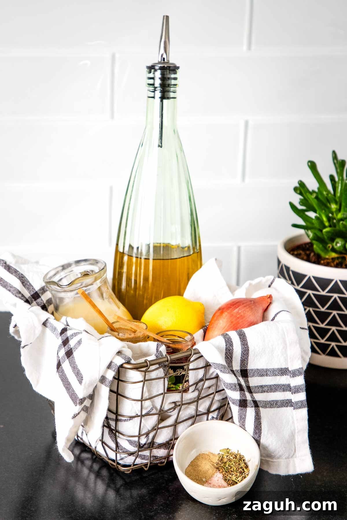 Ingredients to make salad dressing in a basket: olive oil, lemon, shallot, spices.
