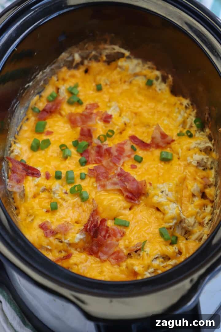 Creamy Slow Cooker Crack Chicken Recipe for Sandwiches & Dips 4 slow cooker crack chicken finished cooking with bacon on top.