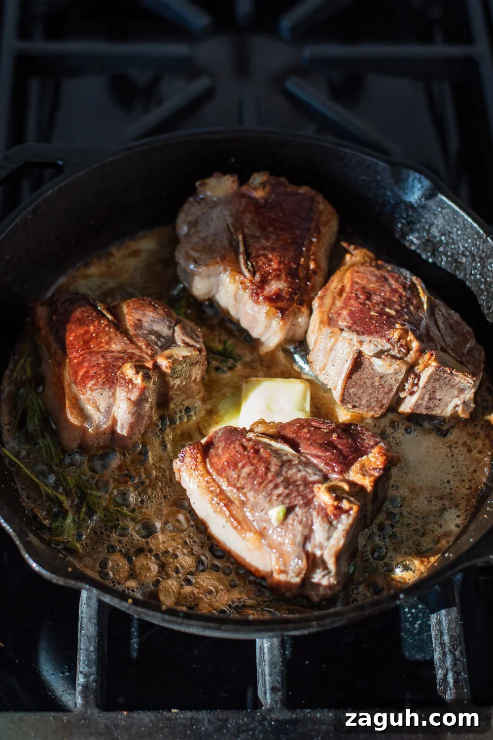 Cognac Butter Lamb Loin Chops Recipe for Elegant Dinner 3 Lamb searing in a cast iron skillet with cognac and butter.