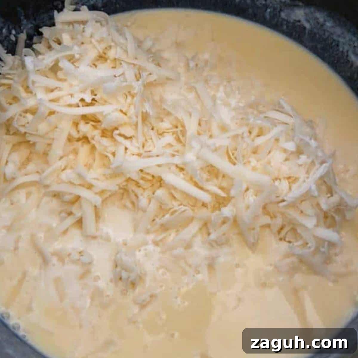 Creamy White Cheddar Mac and Cheese Recipe for Dinner 7 Cheese in roux in skillet macaroni and cheese.
