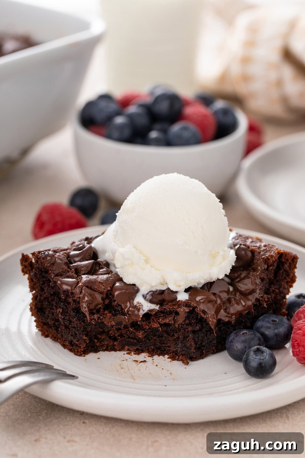Decadent Chocolate Dump Cake Recipe That Melts in Minutes 2 Bite taken from the corner of a slice of chocolate dump cake on a white plate.