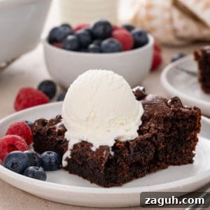 Decadent Chocolate Dump Cake Recipe That Melts in Minutes 12 Slice of chocolate dump cake on a white plate.