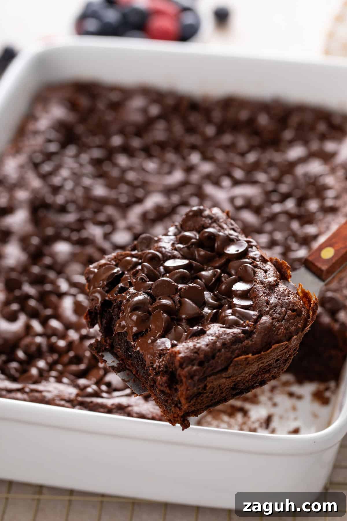 Decadent Chocolate Dump Cake Recipe That Melts in Minutes 3 Cake server lifting a slice of chocolate dump cake up to the camera.