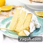 Moist Lemon Coconut Cake with Zesty Glaze 8 slice of lemon coconut cake on a plate with a fork taking a bite out of it