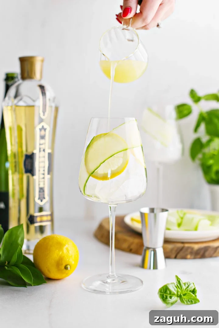St-Germain Spritz Cocktail Recipe: How to Make a Bright French Spritz 8 woman adding fresh lemon juice to a wine glass to make a elderflower prosecco cocktail