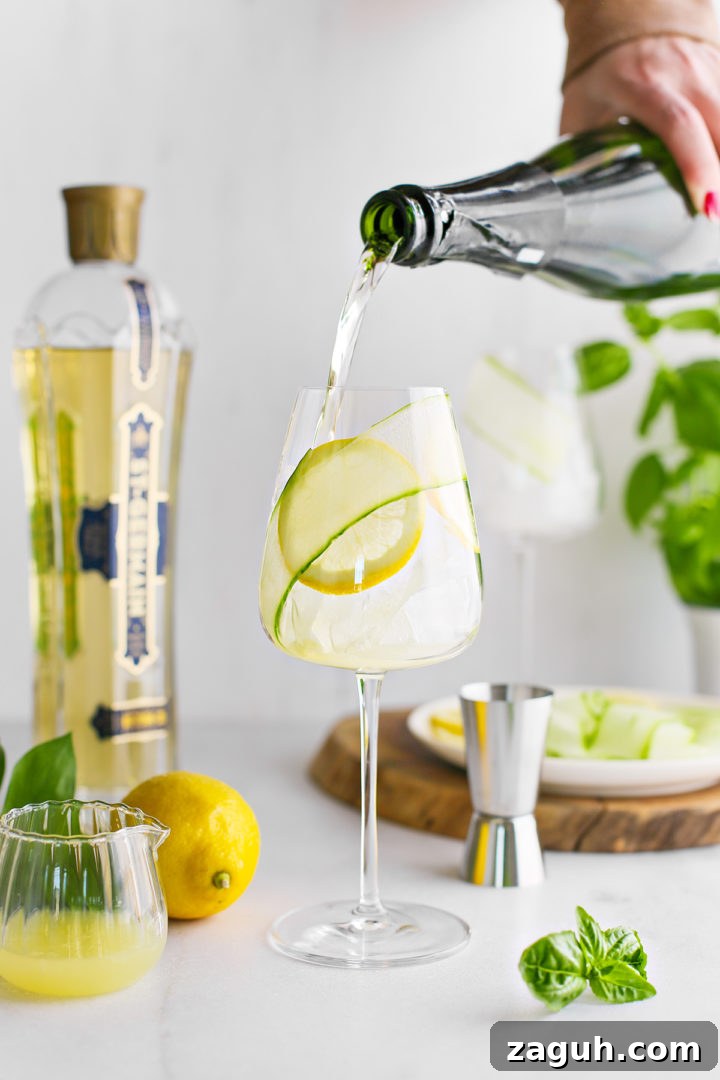 St-Germain Spritz Cocktail Recipe: How to Make a Bright French Spritz 9 woman adding prosecco to a glass of lemon juice to make a st germain spritz