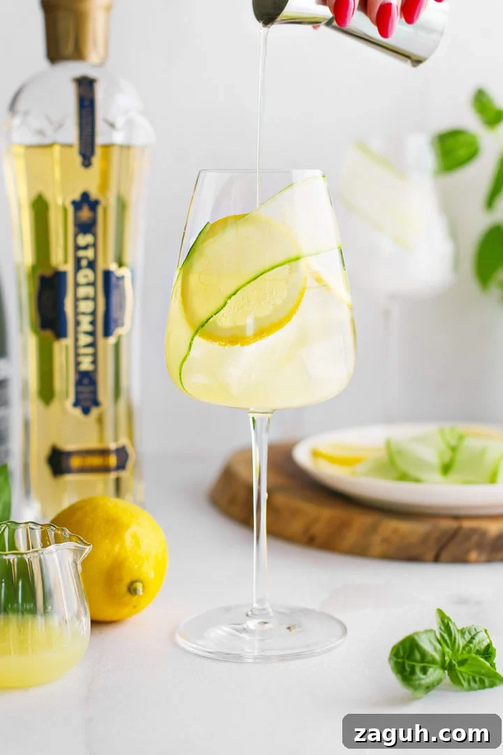 St-Germain Spritz Cocktail Recipe: How to Make a Bright French Spritz 10 woman adding st germain to a glass with prosecco and lemon juice to prepare a recipe for St. Germain prosecco spritz