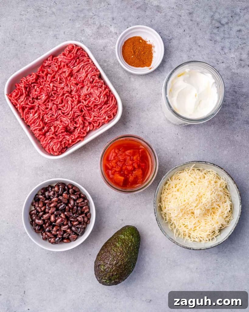 Spicy Chili Cheese Dip Recipe for Parties and Game Day 4 Beef, beans, cheese and tomatoes portioned into bowls for making chili cheese dip.