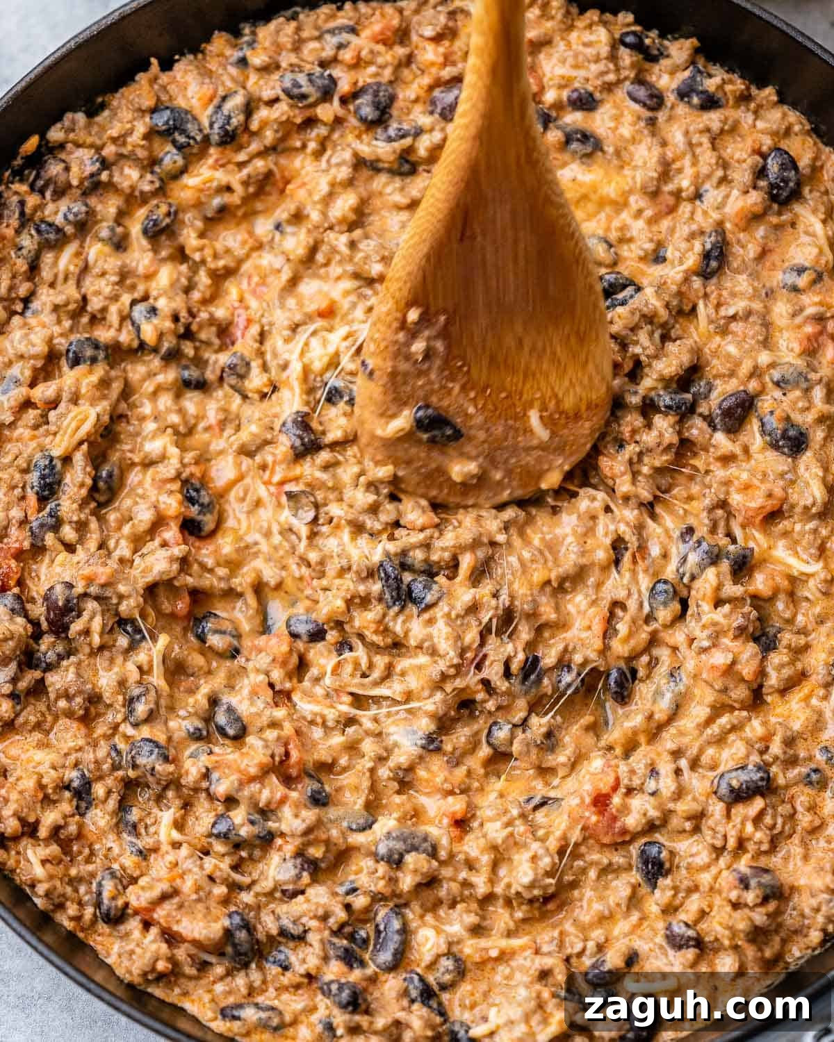 Spicy Chili Cheese Dip Recipe for Parties and Game Day 8 Stirring cheesy dip with a wooden spoon.