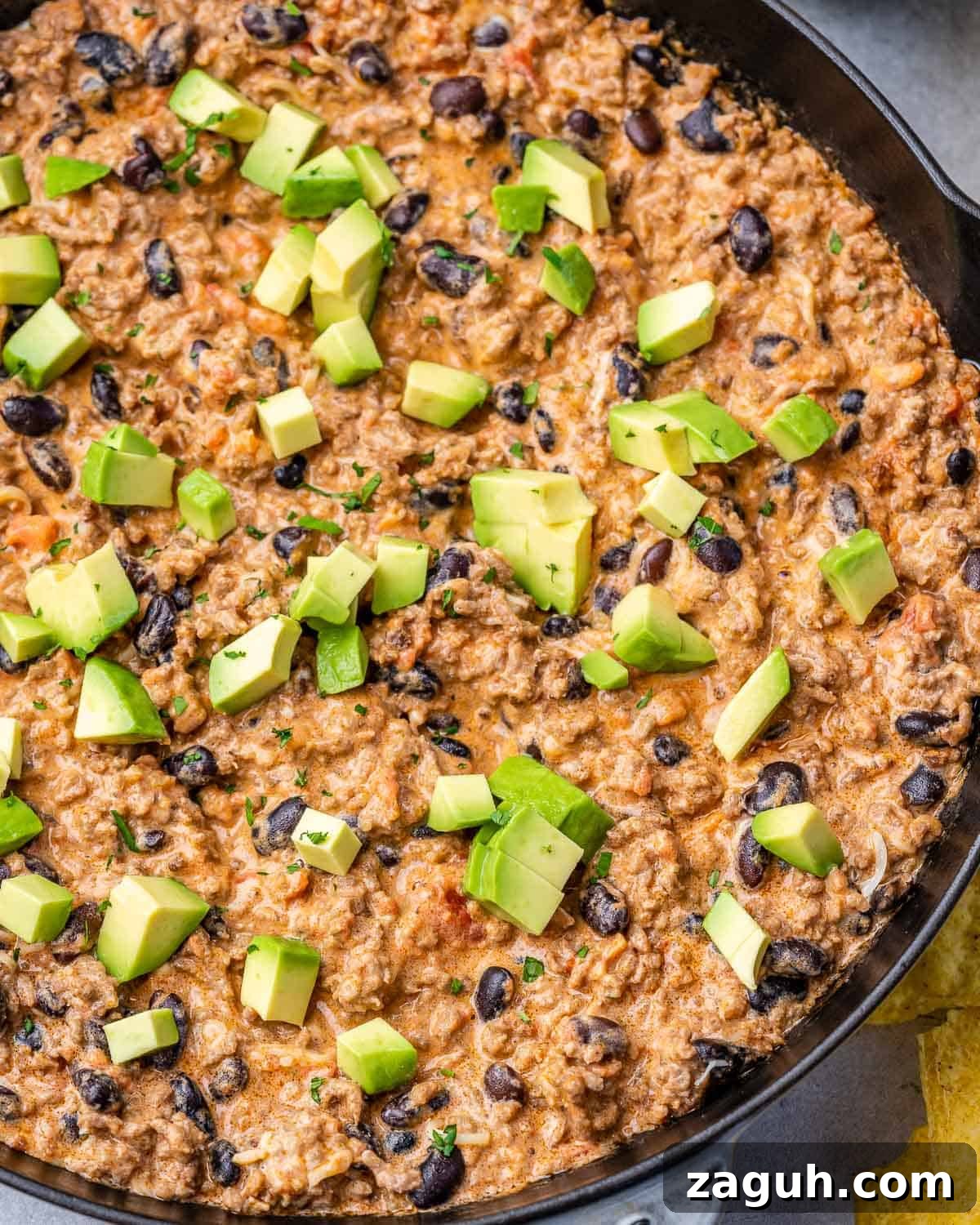 Spicy Chili Cheese Dip Recipe for Parties and Game Day 9 Adding diced avocado over cheese dip.