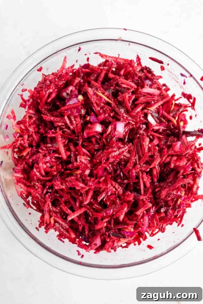 Crisp Apple and Beet Slaw Recipe for Fresh, Tangy Sides 5 A raw beet, cabbage and apple salad in a bowl.