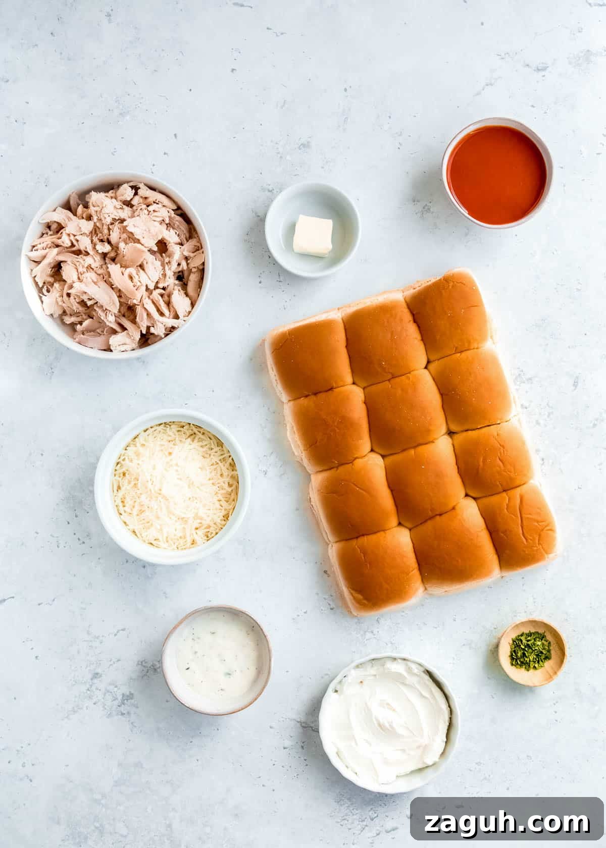 Spicy Buffalo Chicken Sliders with Blue Cheese Slaw 3 all ingredients needed for buffalo chicken sliders on a white table
