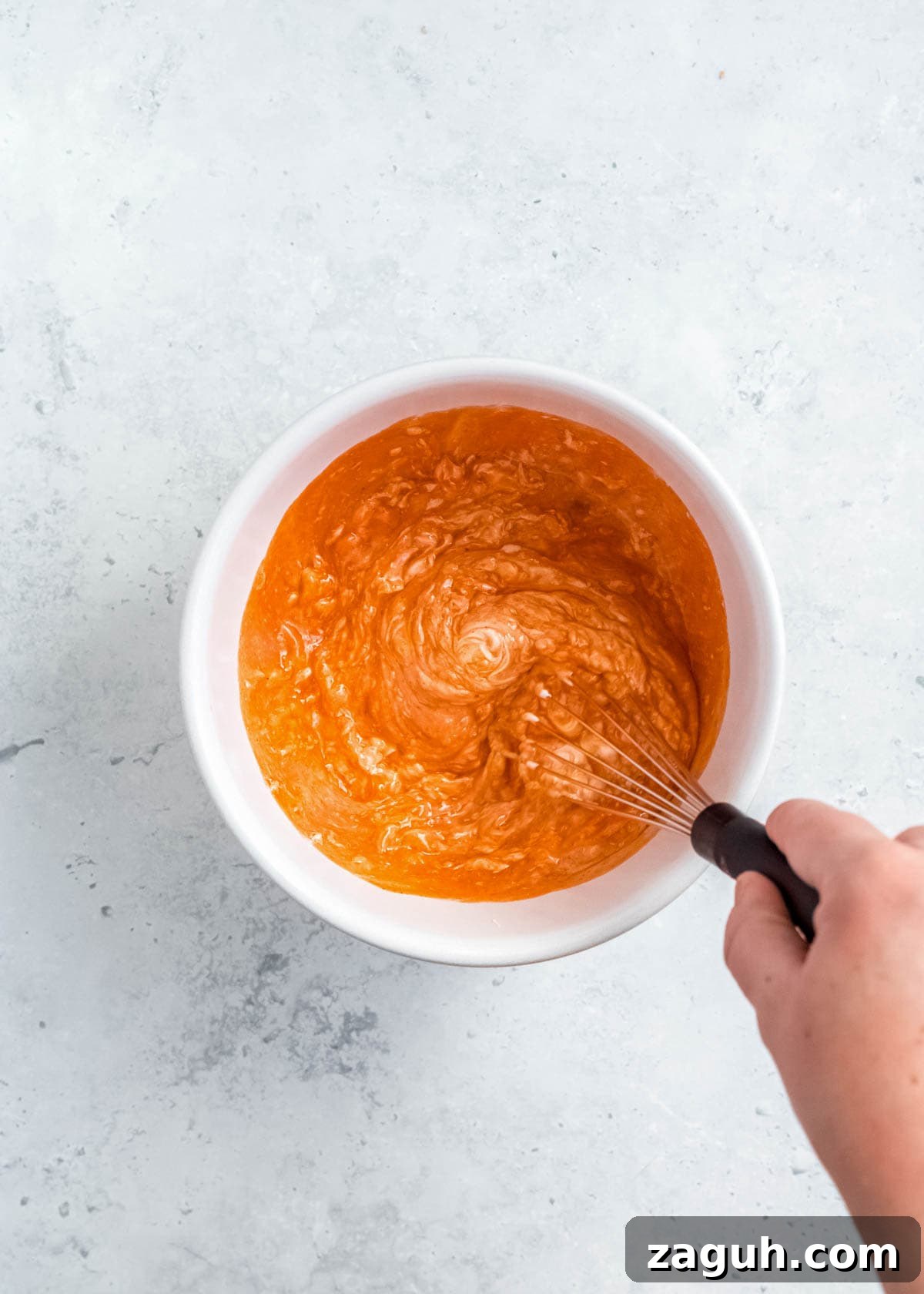 Spicy Buffalo Chicken Sliders with Blue Cheese Slaw 4 buffalo sauce and softened cream cheese being mixed in a white bowl