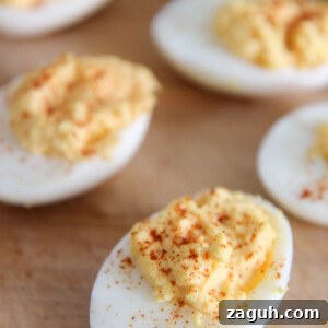 Perfect Classic Deviled Eggs Recipe for Parties and Holidays 5 deviled eggs with paprika on a wooden board