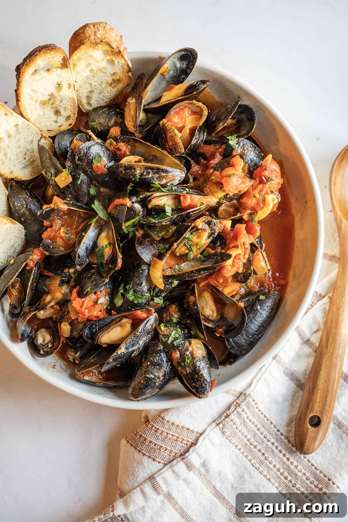 Mussels Fra Diavolo in a serving bowl with crostini.