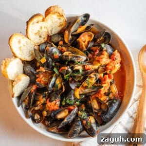 Mussels Fra Diavolo in a serving bowl with crostini.