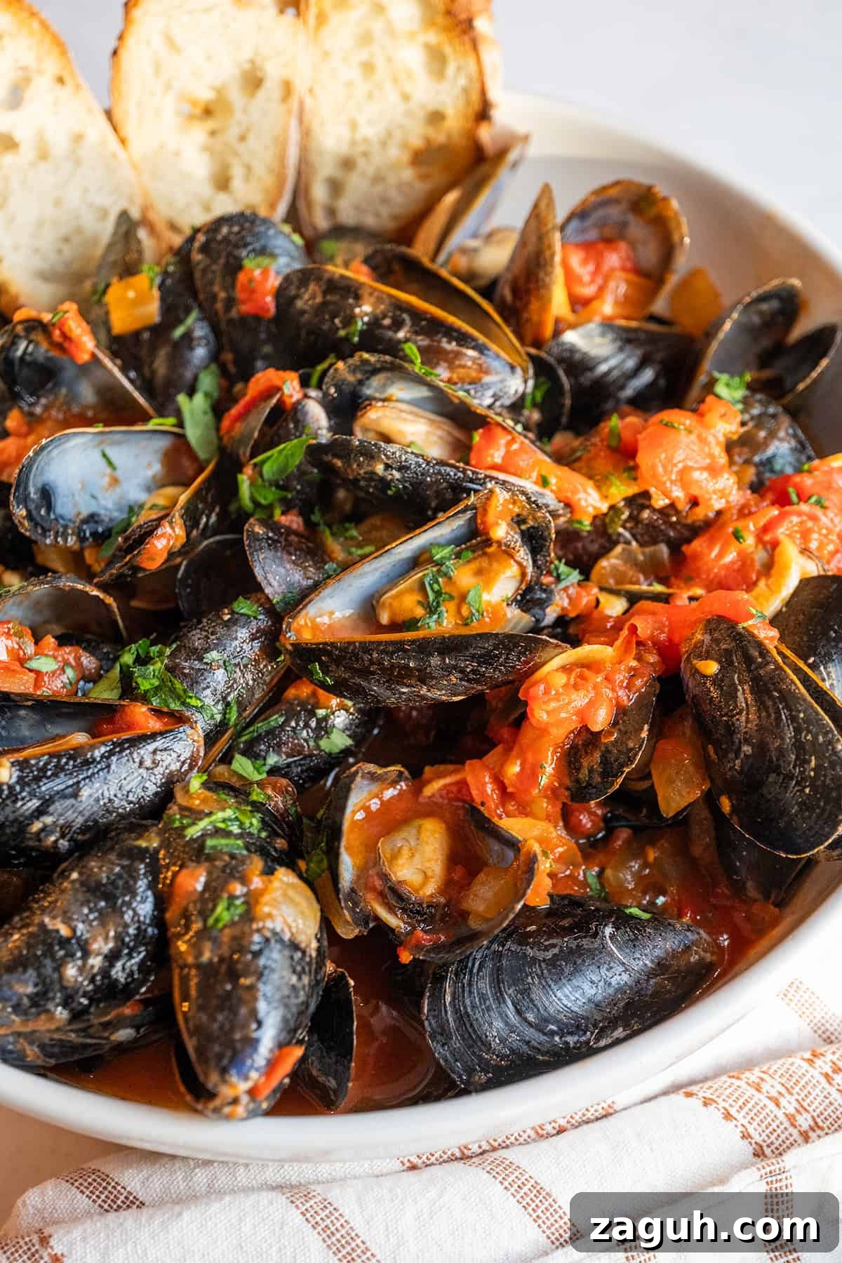 Mussels Fra Diavolo in a serving bowl with crostini.