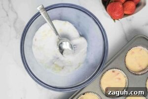 Fresh Strawberry Sourdough Muffins Recipe for Soft, Tangy Loaves 8 Mixing bowl with lemon sugar topping and a spoon, next to a muffin tin filled with batter.