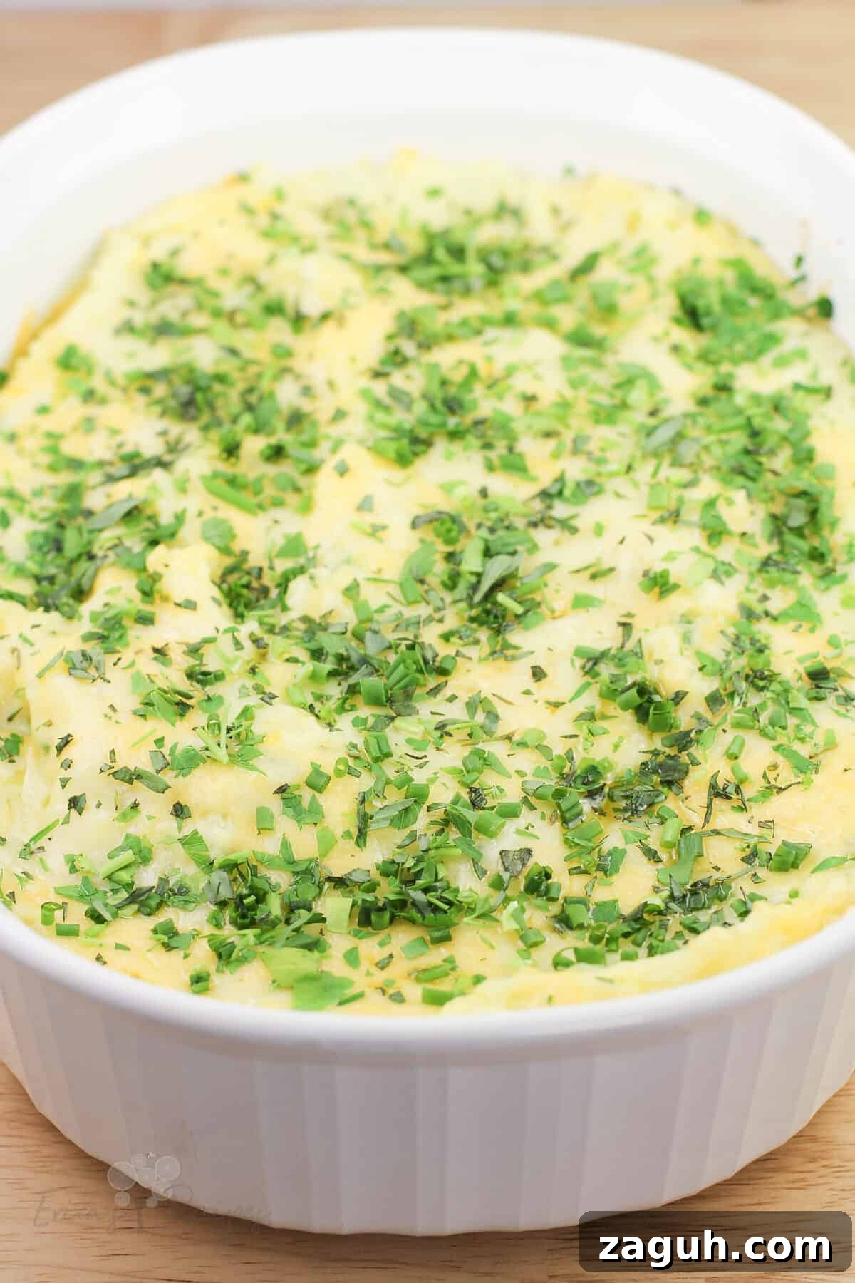 Creamy Gruyère, Garlic & Gouda Mashed Potatoes Recipe 2 top, angled view into white dish of prepared guyere, garlic, and gouda mashed potatoes