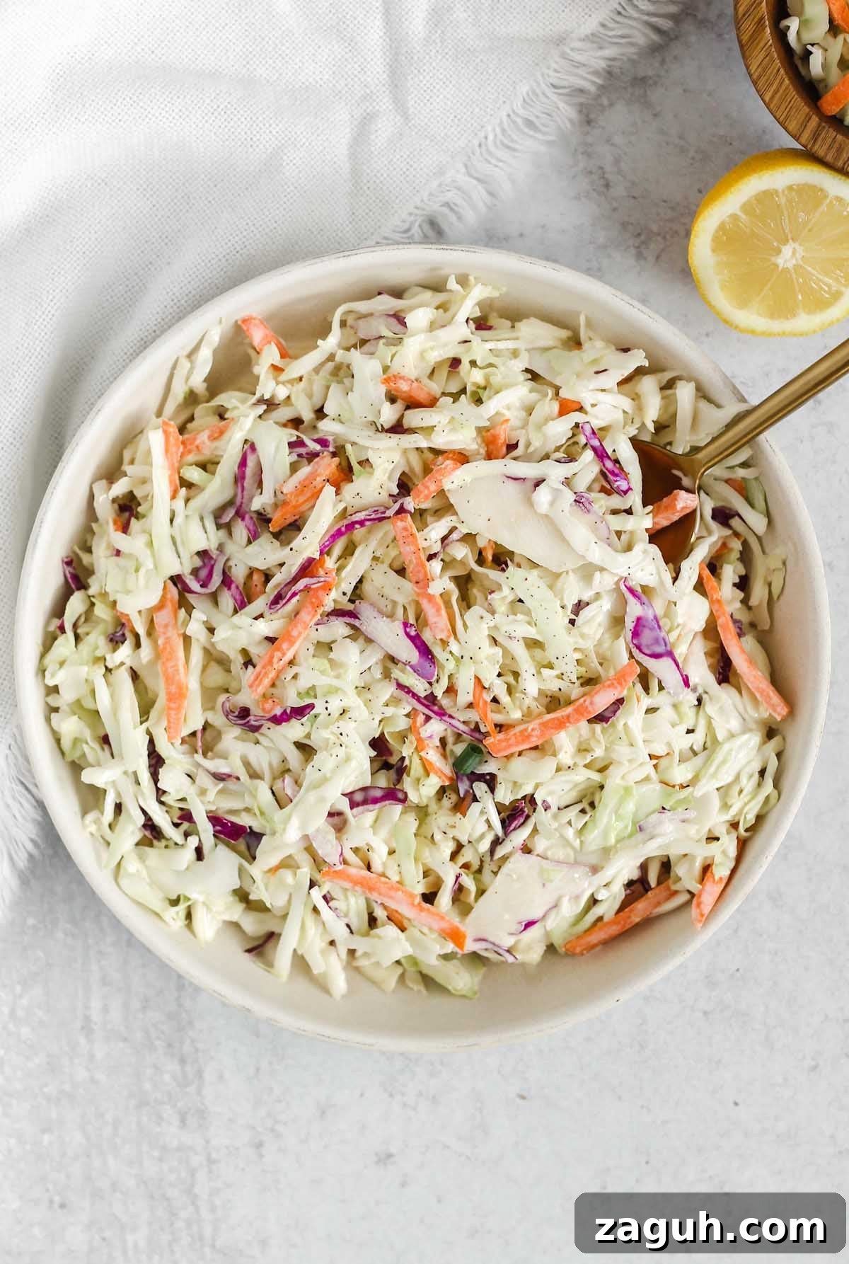 Creamy Paleo & Whole30 Coleslaw Recipe for Simple Sides 2 Whole30/Paleo coleslaw in a serving dish with a gold spoon.