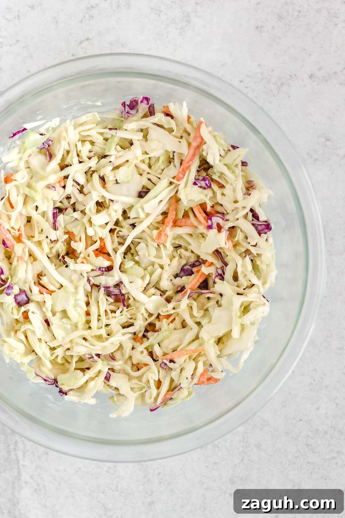 Creamy Paleo & Whole30 Coleslaw Recipe for Simple Sides 6 Coleslaw mixed with dressing in a mixing bowl.