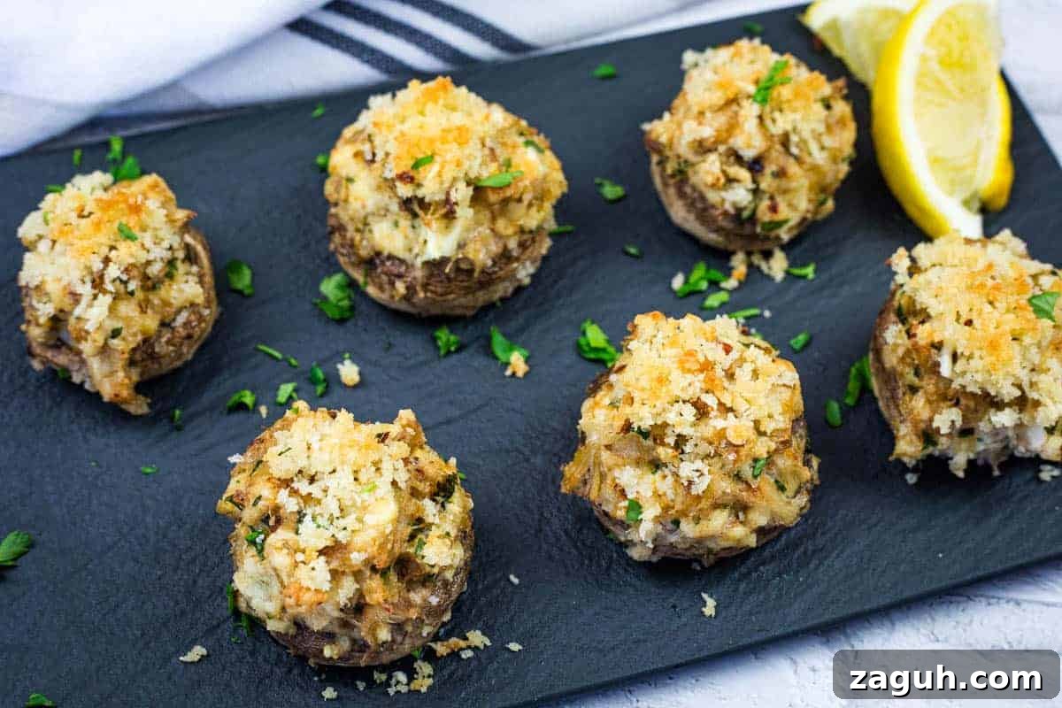31 Bold Seafood Recipes for Big Flavor with Simple Ingredients 12 A slate platter with six crab stuffed mushrooms garnished with herbs.