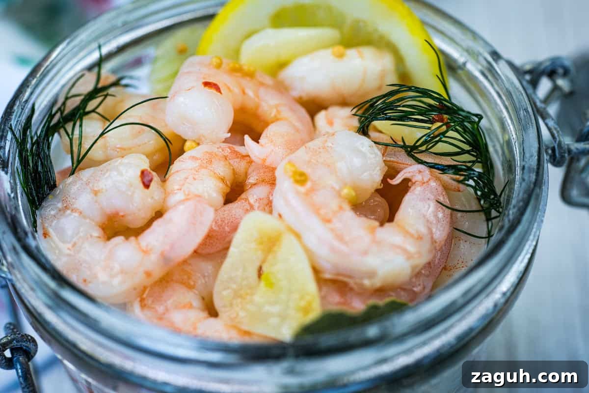 31 Bold Seafood Recipes for Big Flavor with Simple Ingredients 22 Close-up Southern Style Pickled Shrimp with lemon slices and dill on a jar.