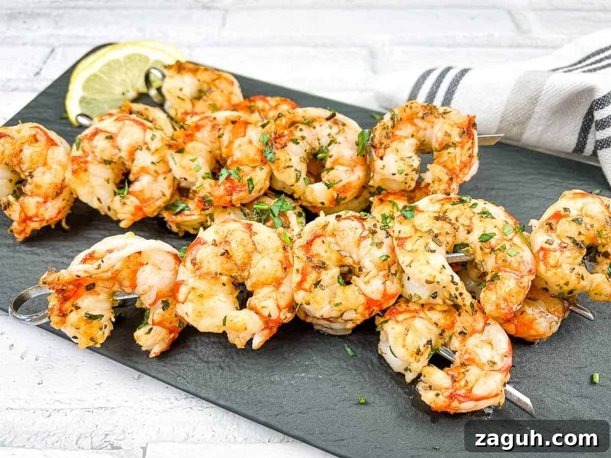 31 Bold Seafood Recipes for Big Flavor with Simple Ingredients 26 Shrimp skewers on a white plate with lemon wedges.