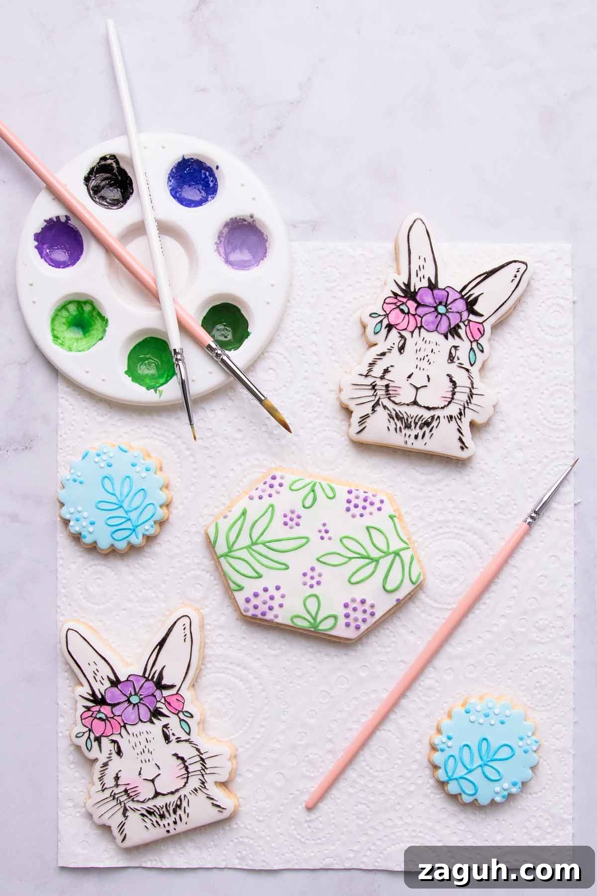 Stamped Fondant Cookies: Step-by-Step Guide for Beautiful Designs 12 Two painted floral bunny cookies in pastel shades, with a leaf-patterned painted embossed cookie in shades of green.