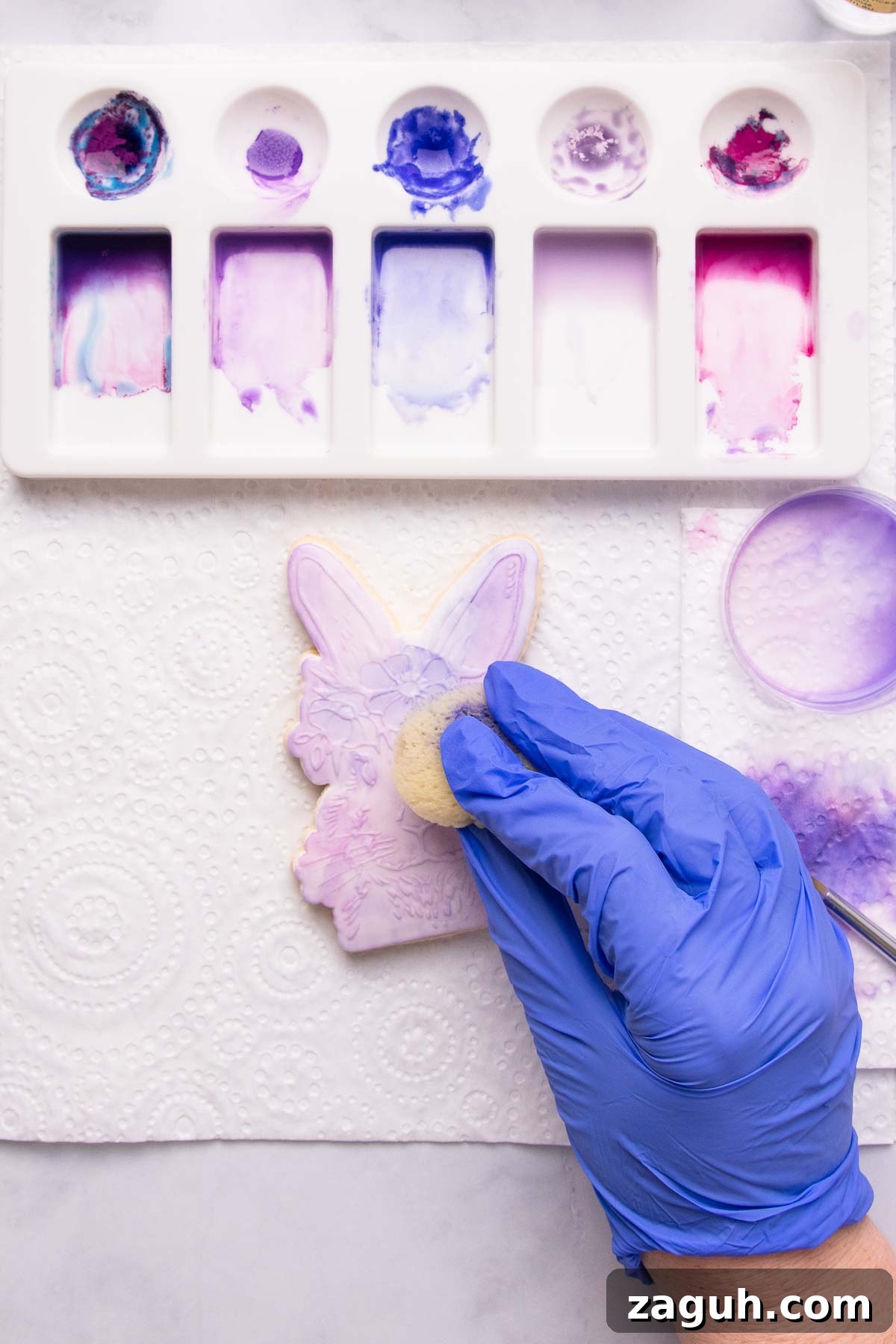 Stamped Fondant Cookies: Step-by-Step Guide for Beautiful Designs 14 Sponge painting a stamped fondant cookie to create soft background color.