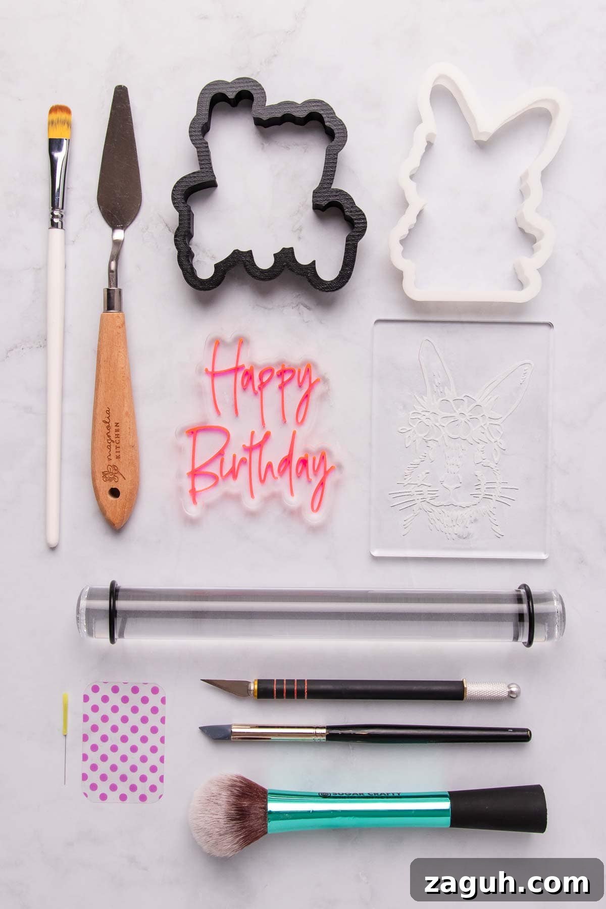 Stamped Fondant Cookies: Step-by-Step Guide for Beautiful Designs 5 A flat-lay of the tools needed to make stamped fondant cookies - stamps, cookie cutters, rolling pin, fondant smoothers, paintbrushes, a palette knife and a modelling tool.