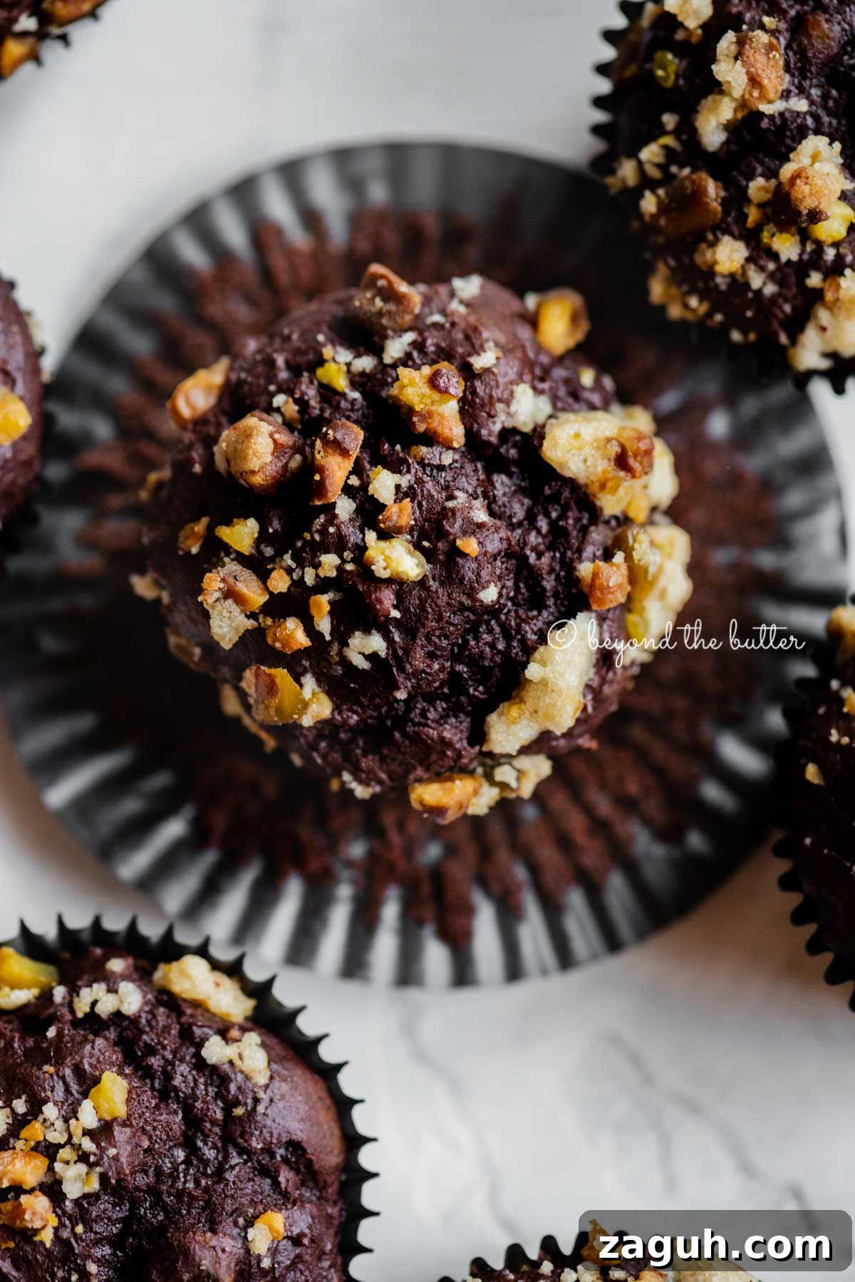 Dark Chocolate Pistachio Cream Cheese Muffins Recipe 2 Dark chocolate pistachio cream cheese muffins with center muffin unwrapped | All Images © Beyond the Butter™