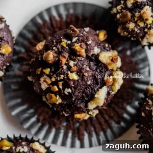 Dark Chocolate Pistachio Cream Cheese Muffins Recipe 8 Dark chocolate pistachio cream cheese muffins with center muffin unwrapped on light great background.