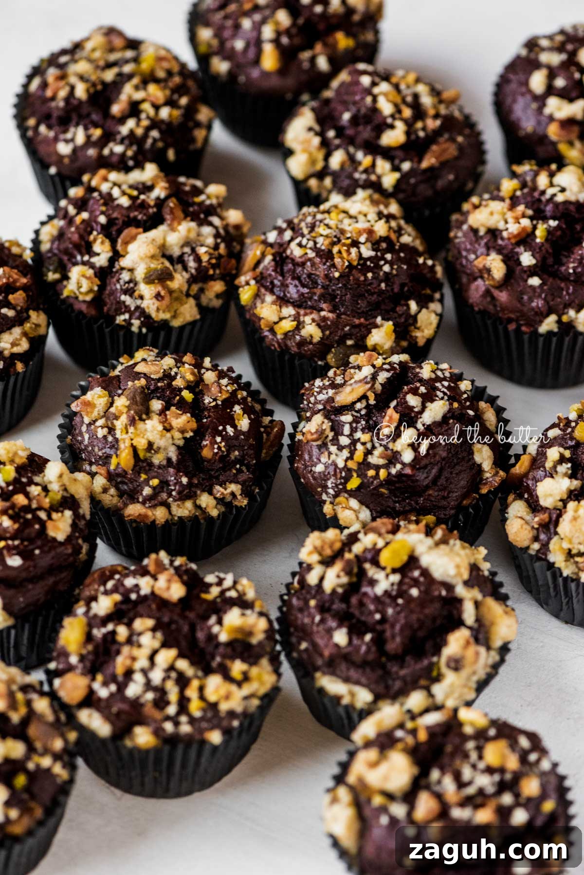 Dark Chocolate Pistachio Cream Cheese Muffins Recipe 3 Randomly places dark chocolate pistachio cream cheese muffins on gray background | All Images © Beyond the Butter®