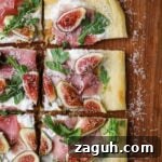Fig, Burrata & Prosciutto Pizza with Honey and Arugula 11 White pizza with fig, prosciutto, arugula, and burrata on a wooden serving board.