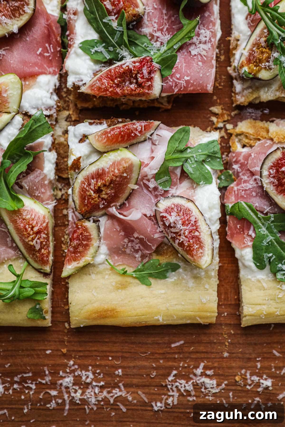 Fig, Burrata & Prosciutto Pizza with Honey and Arugula 6 Slice of white fig pizza topped with fresh figs, sliced prosciutto, globs of burrata, and fresh and peppery arugula.