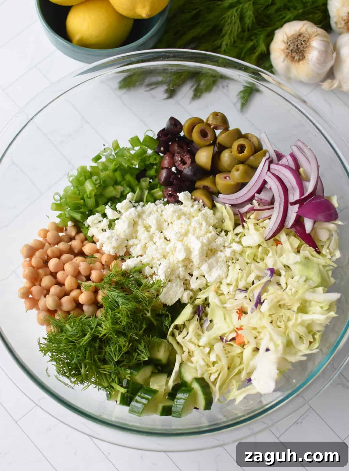 Greek Cabbage Salad Recipe with Feta and Lemon Dressing 8 Greek Cabbage Salad ingredients in a large clear bowl