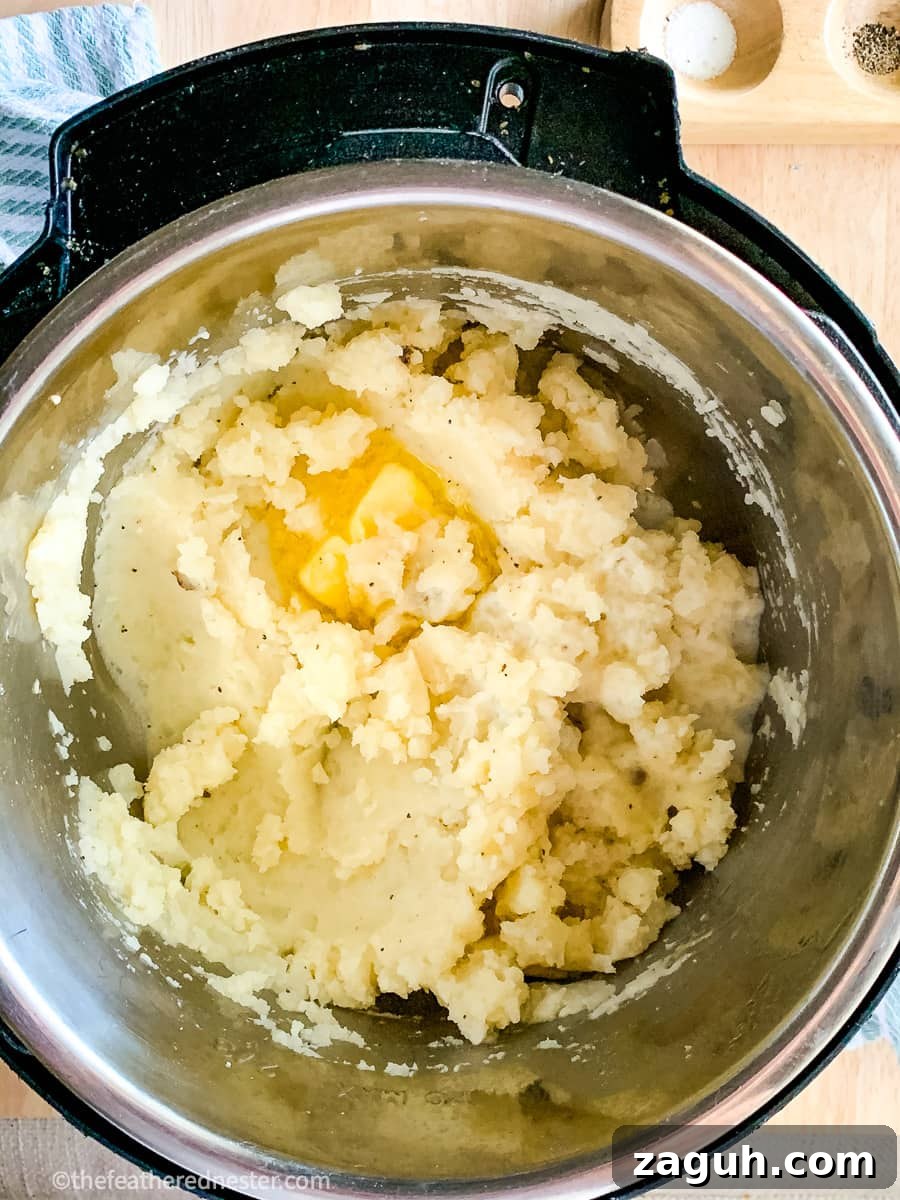 Instant Pot Mashed Potatoes Without Draining 5 Instant Pot mashed potatoes with butter melting over them in the pressure cooker.