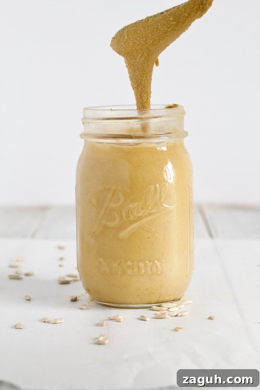 Homemade Sunflower Seed Butter: Smooth, Creamy Recipe 4 Homemade Sunflower Butter Recipe in Glass Jar Pouring into Jar