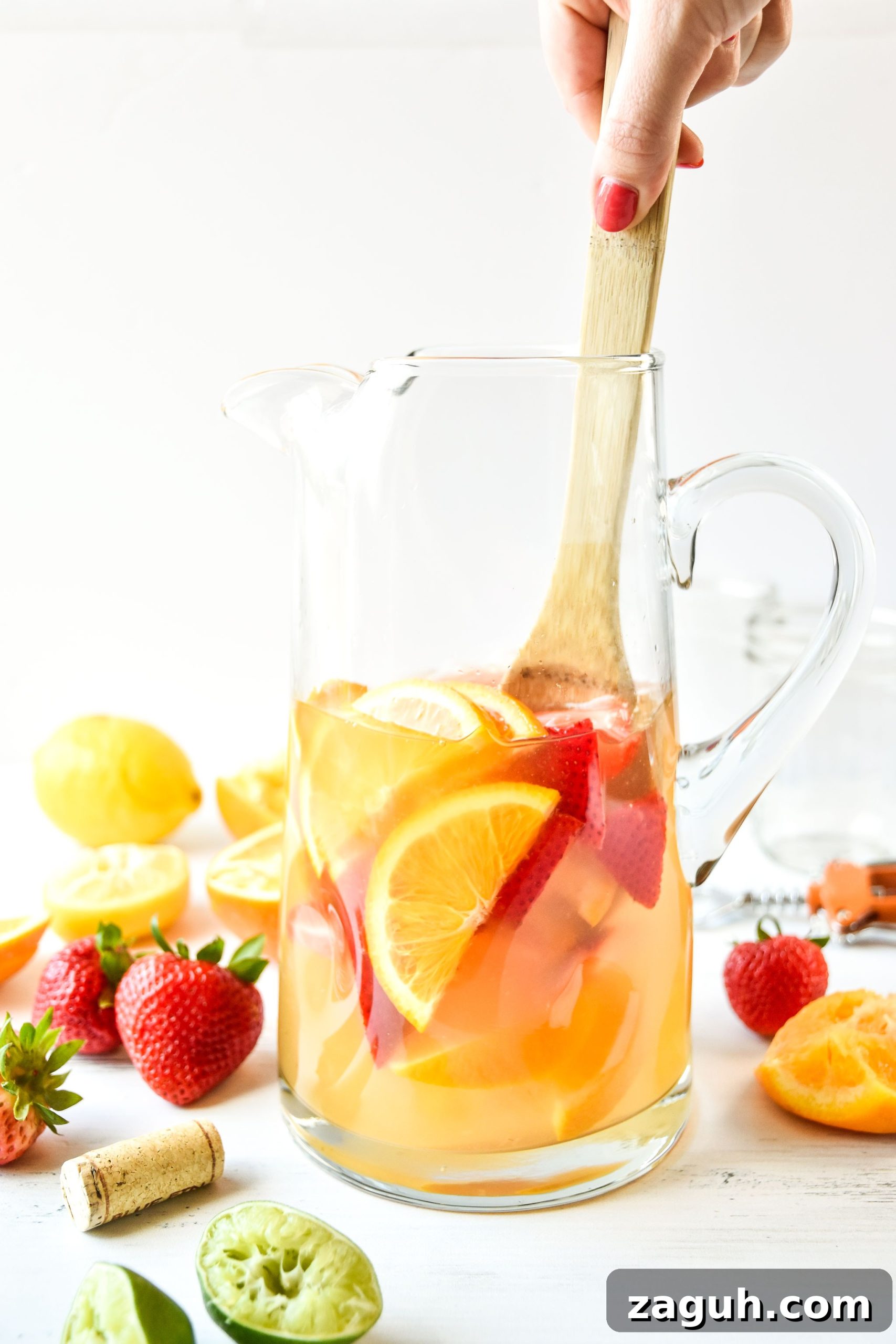 Refreshing Summer White Wine Sangria Recipe for Warm Evenings 2 Pitcher of summer white wine sangria being stirred