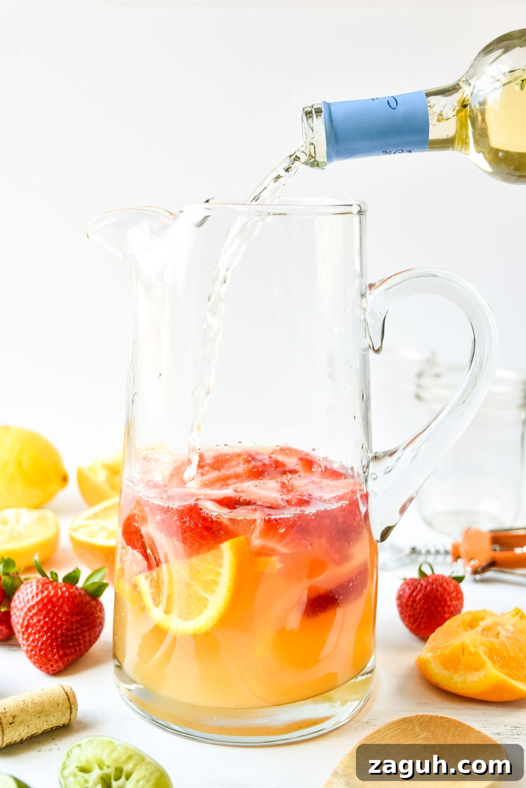 Refreshing Summer White Wine Sangria Recipe for Warm Evenings 3 Pouring wine into pitcher of summer white wine sangria